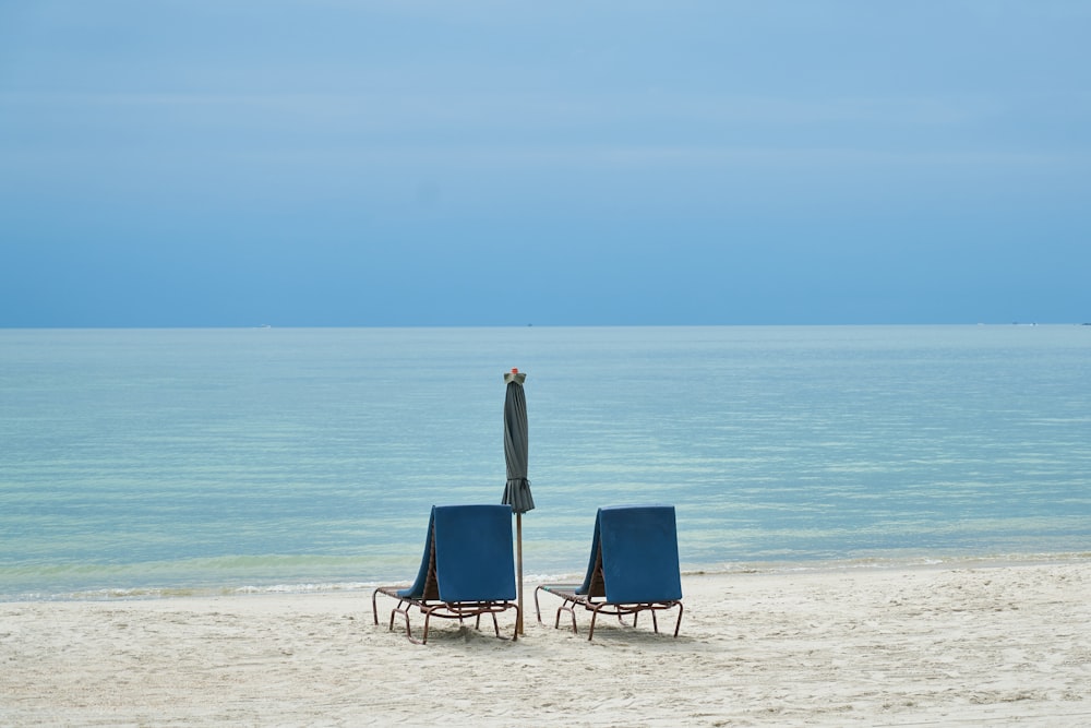 blue and white beach chair on beach during daytime