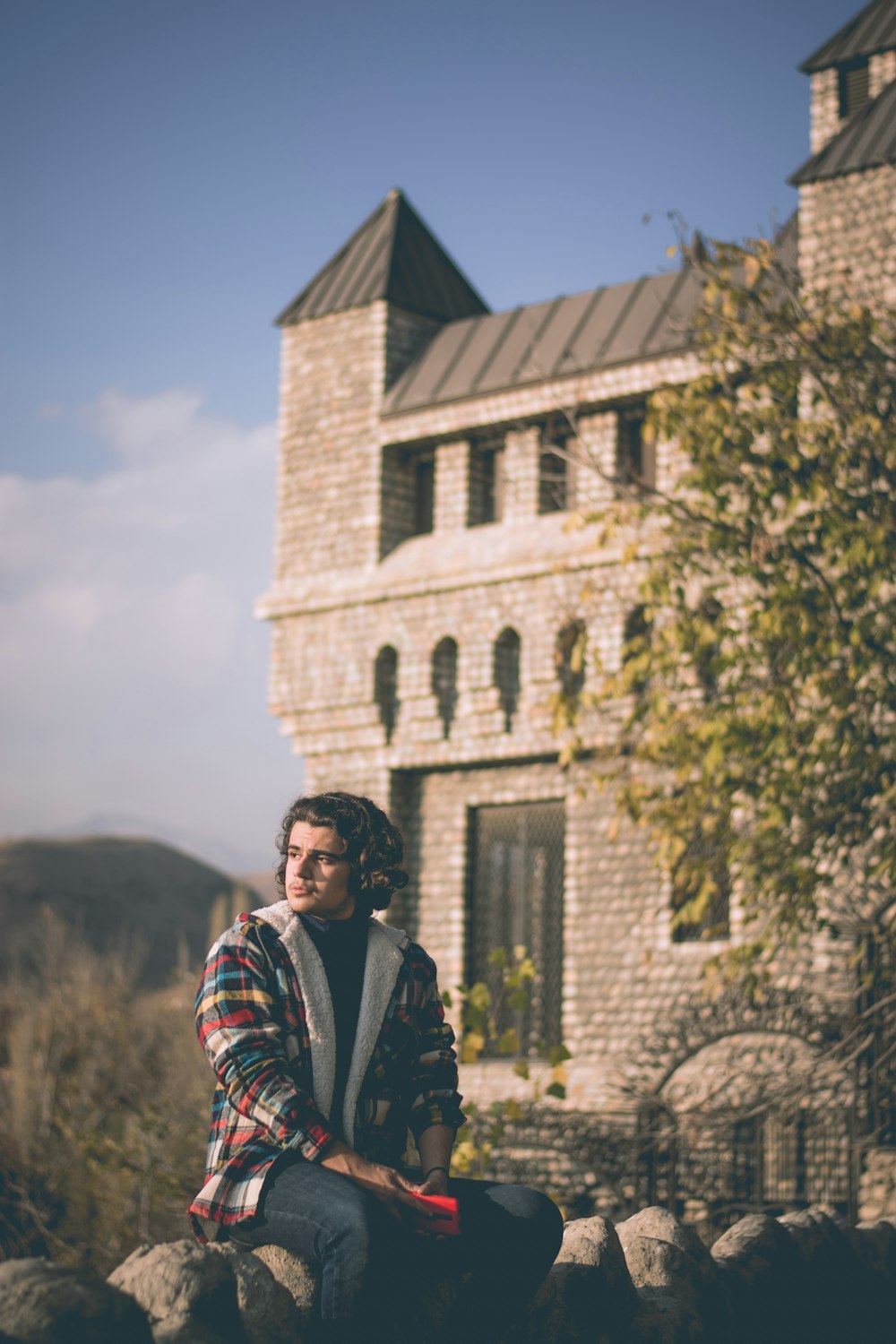 man in black jacket standing near brown concrete building during daytime