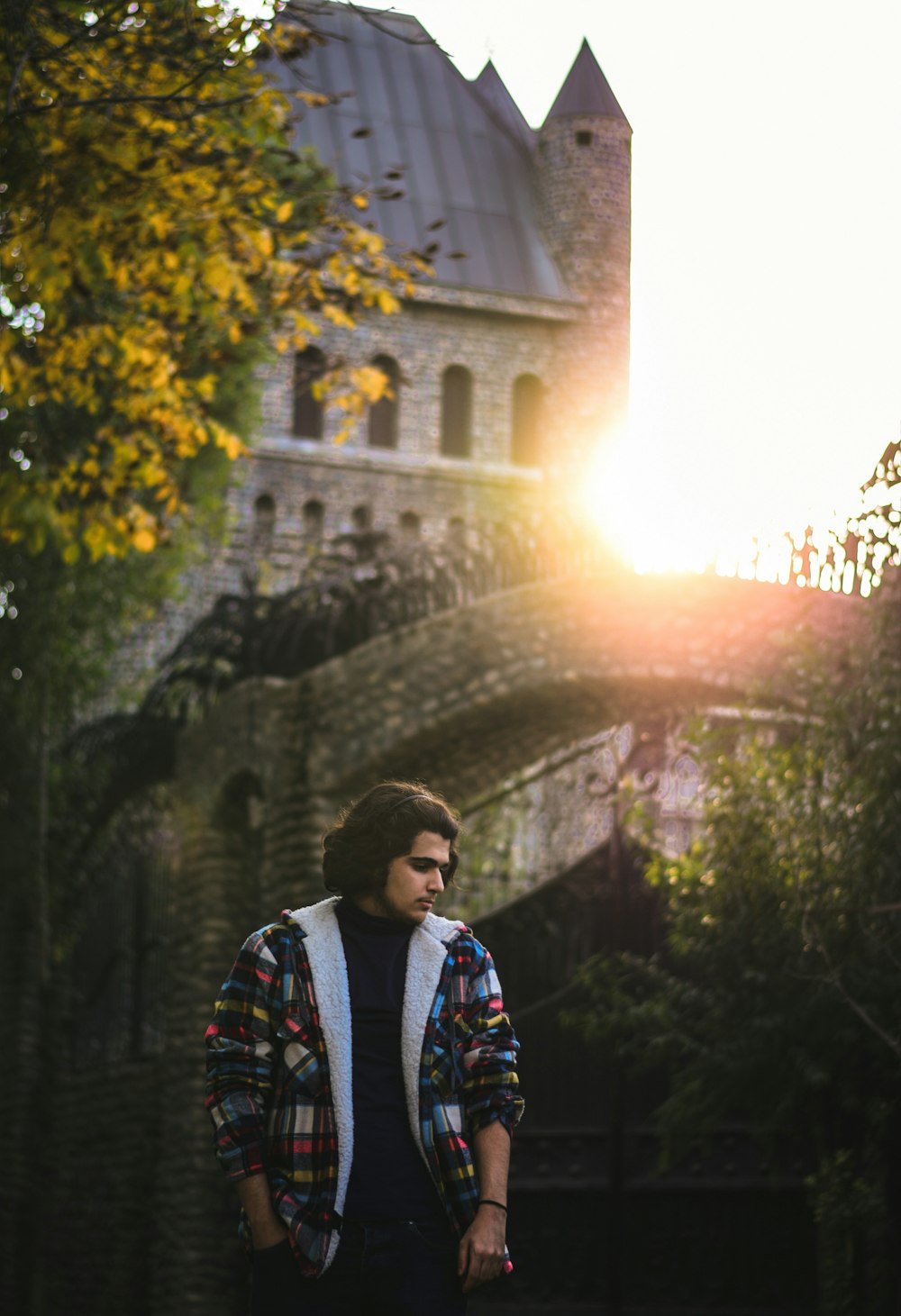 man in red and black jacket standing near green plants during daytime