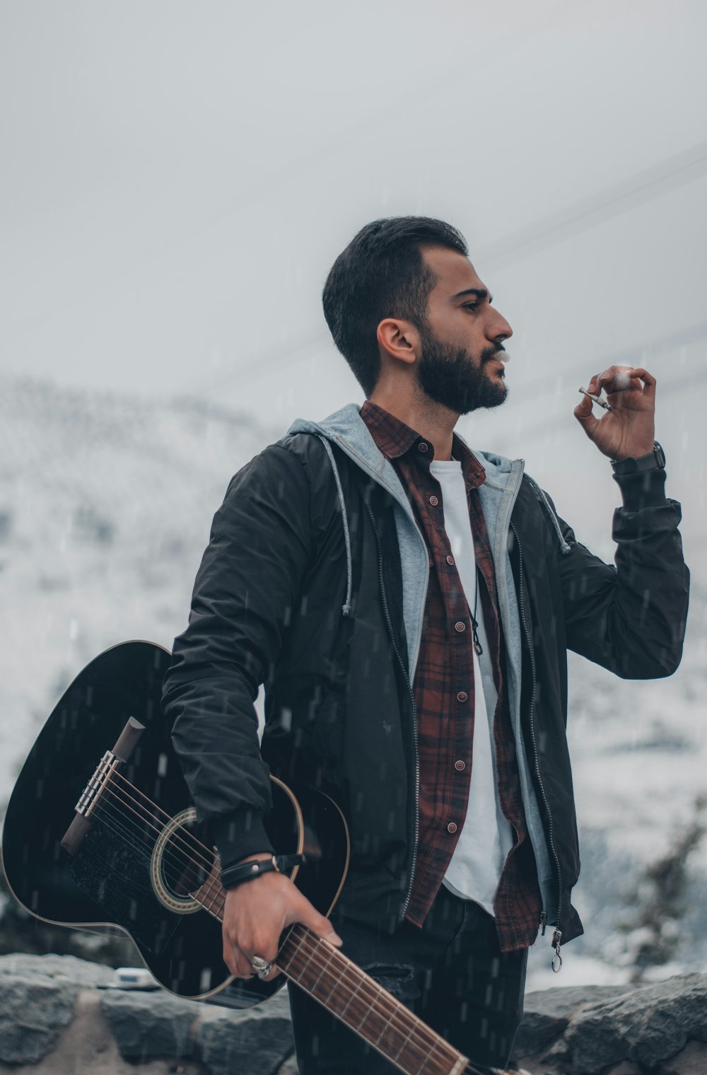 man in black jacket holding black camera