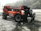 Large orange forklift-style construction vehicle with 'EquipmentShare' branding, parked on a wet and slightly snowy surface, surrounded by a misty forest and power lines in the background.