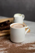 A steaming mug of cocoa made from magnesium cocoa powder, surrounded by cocoa beans.