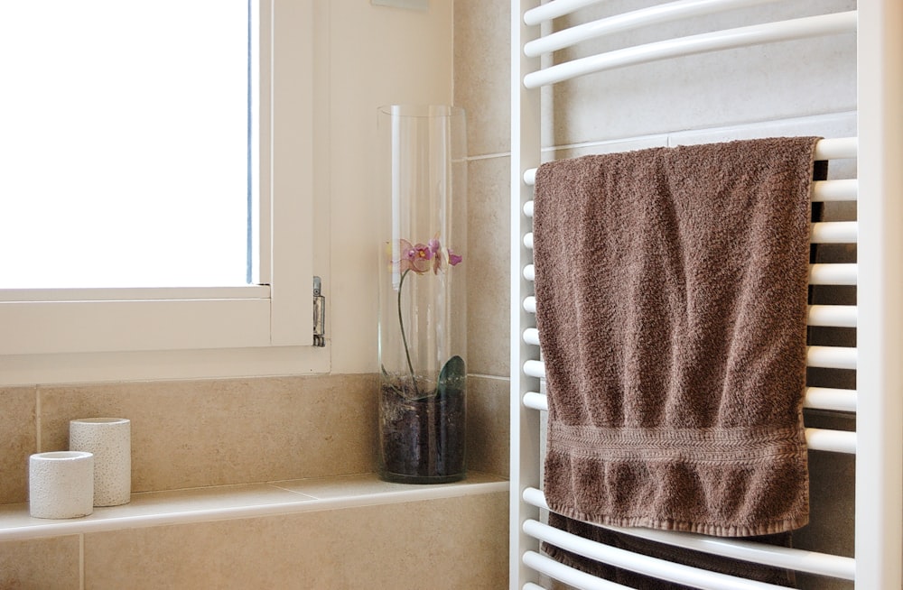 pink towel on white metal rack