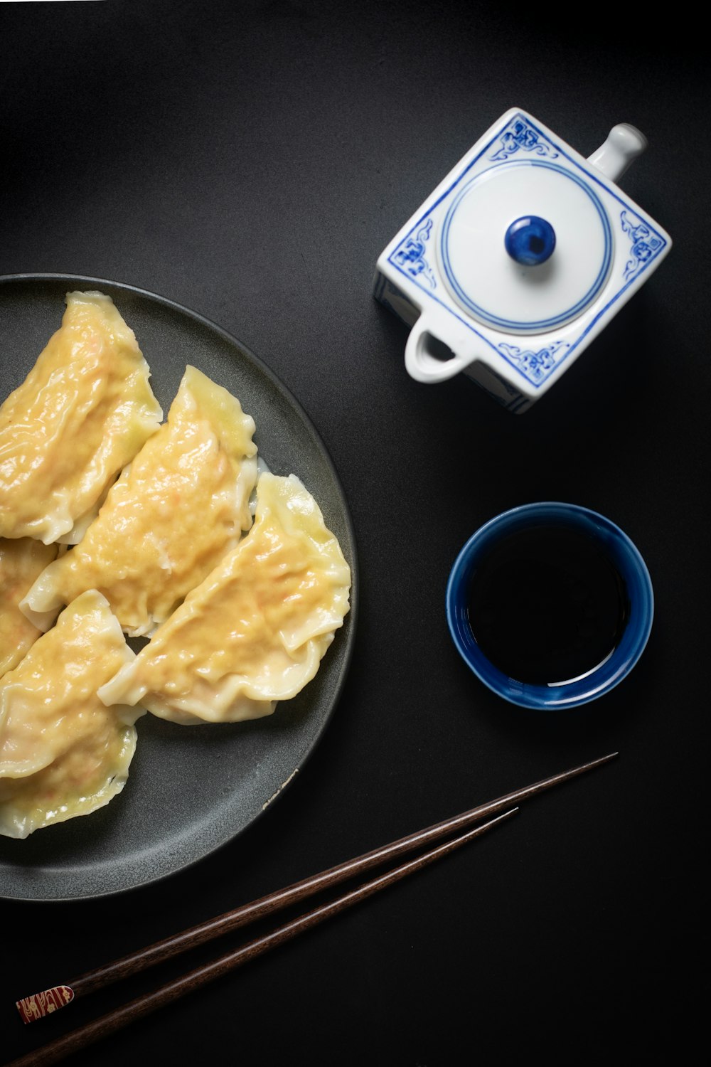 white ceramic mug beside black ceramic plate with food