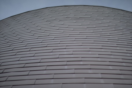 Curved zinc sheet metal accents wrapping a high-end residential exterior.