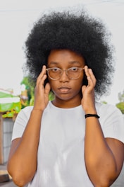 woman in white crew neck shirt wearing black framed eyeglasses