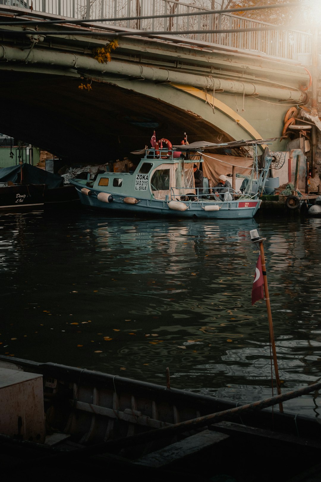 white and blue boat on water under bridge during daytime