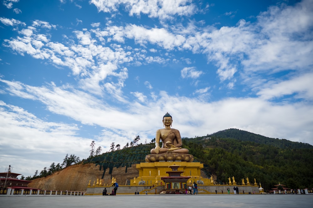 Estatua de Buda de oro bajo el cielo azul durante el día