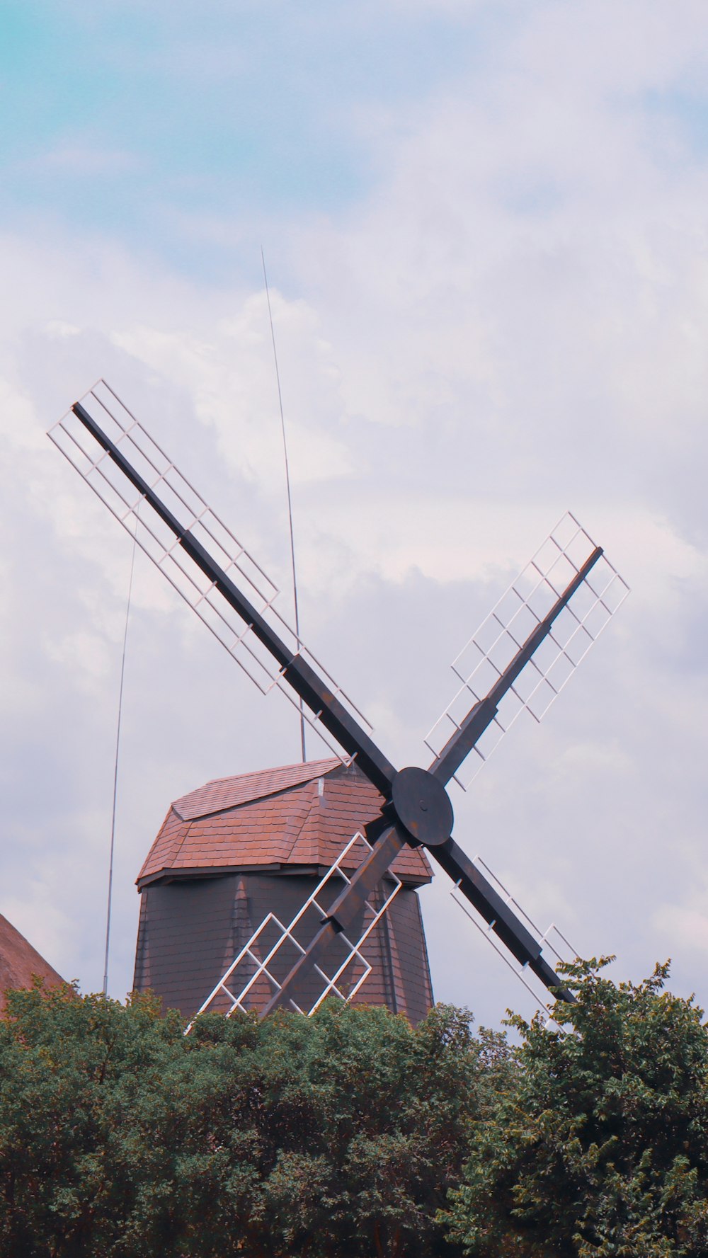 Moulin à vent noir et blanc sous des nuages blancs