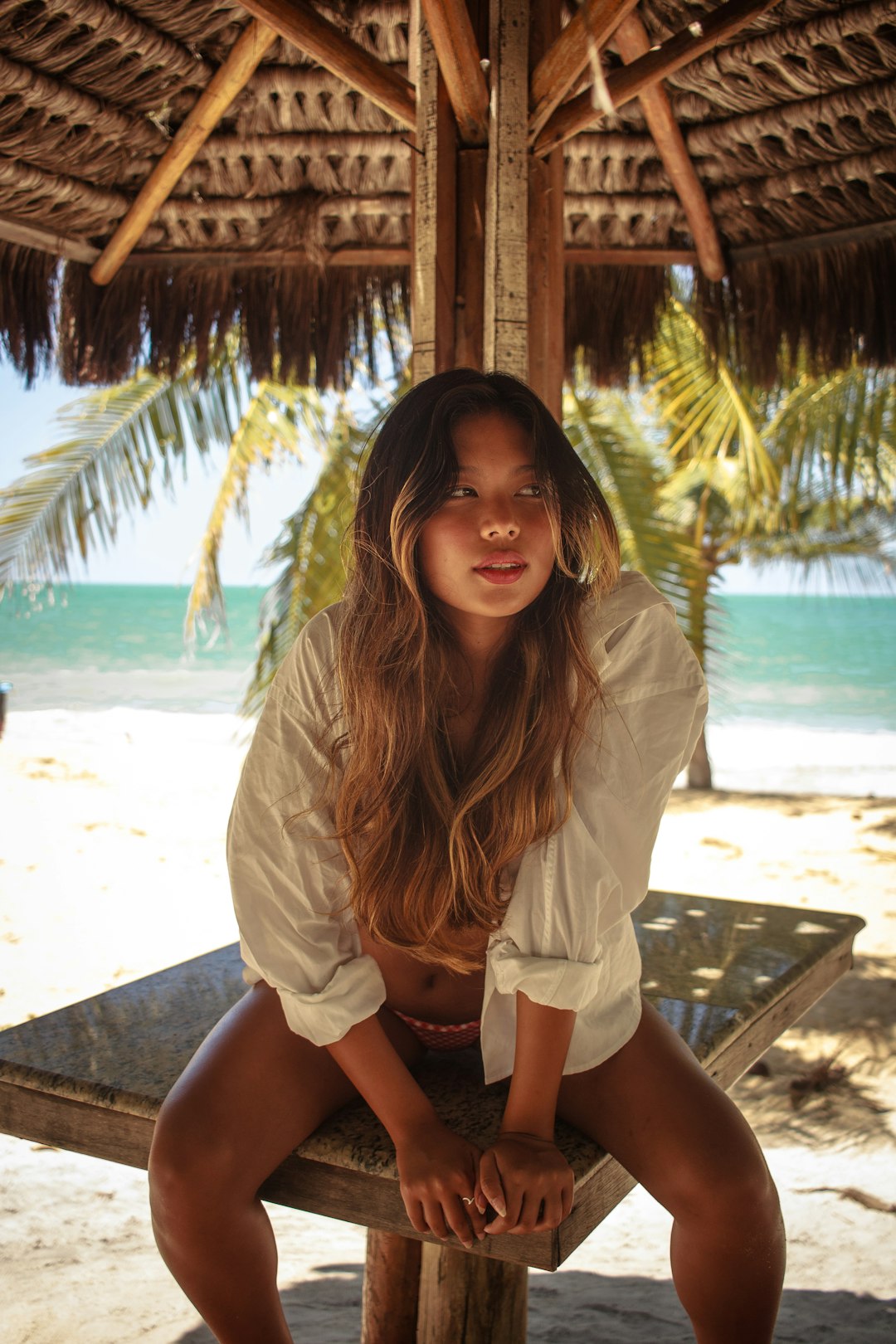 woman in white shirt sitting on brown wooden bench