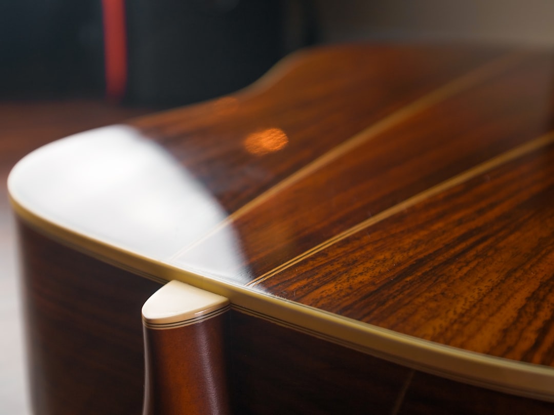 brown wooden guitar with white plastic handle