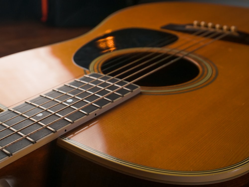 brown acoustic guitar on black and white textile