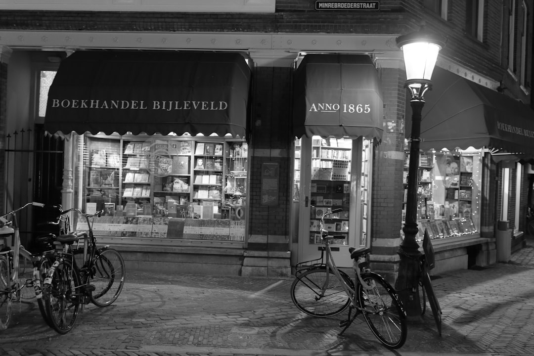 grayscale photo of bicycle parked beside store