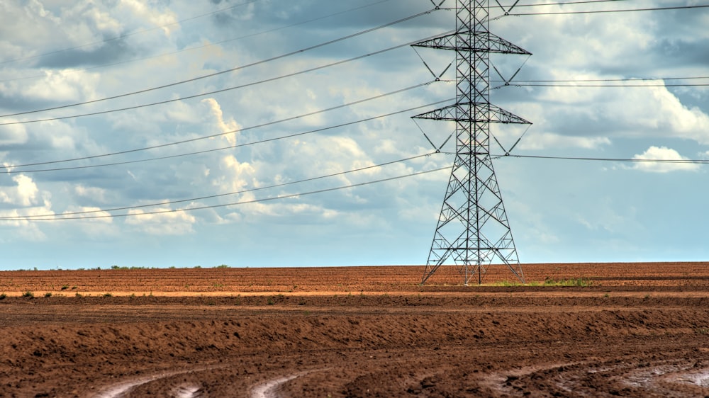 gray metal electric towers under blue sky during daytime