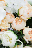 An elegant bridal bouquet with soft pink peonies and trailing greenery