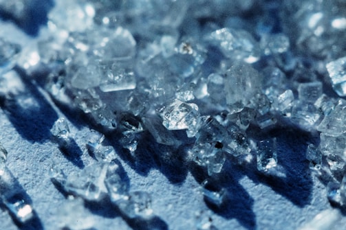 Close-up of crystals reflecting light on a dark surface.