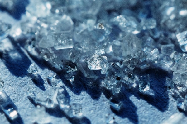 Closeup of sugar crystals on a blue surface.