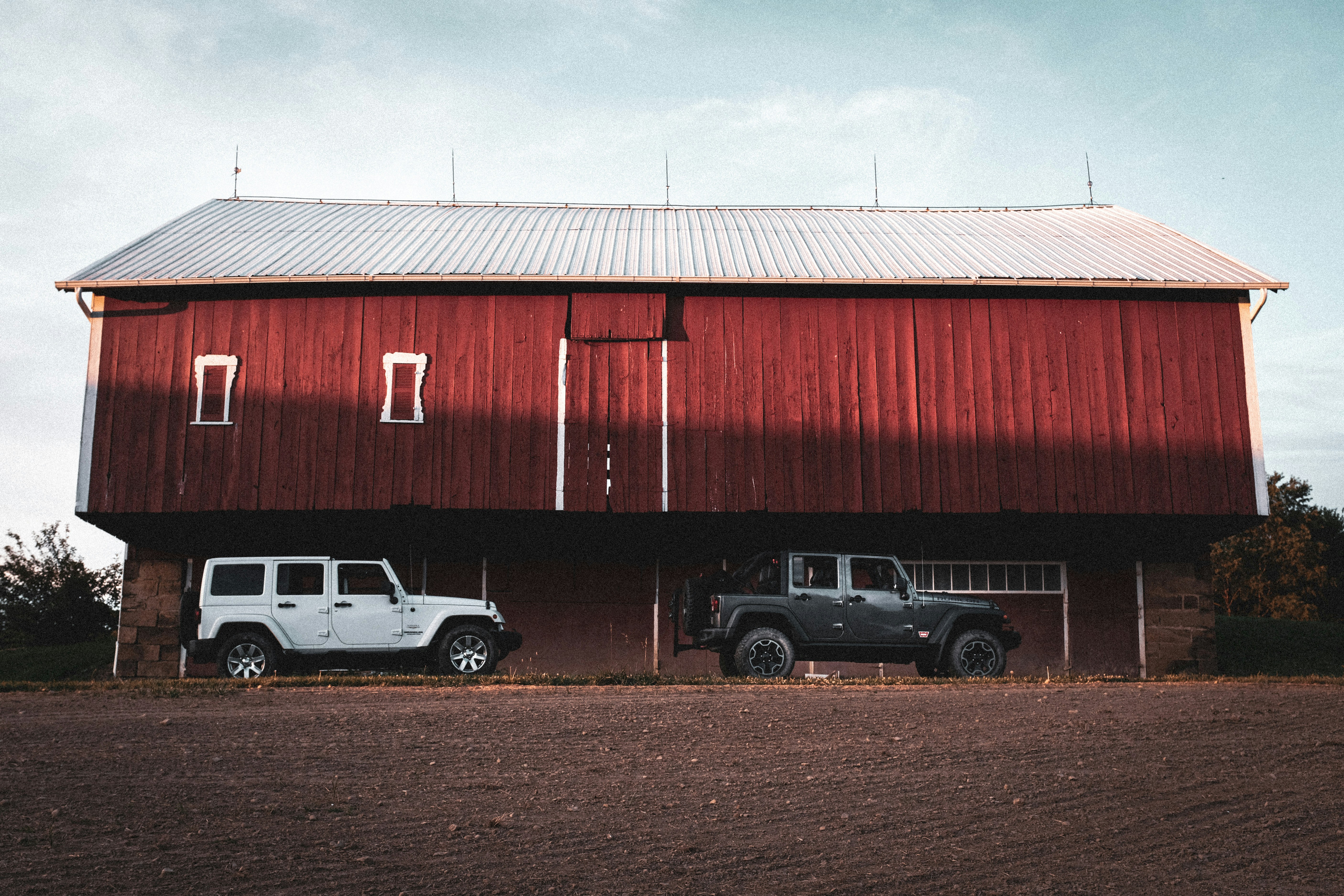 white and black cars parked beside red building