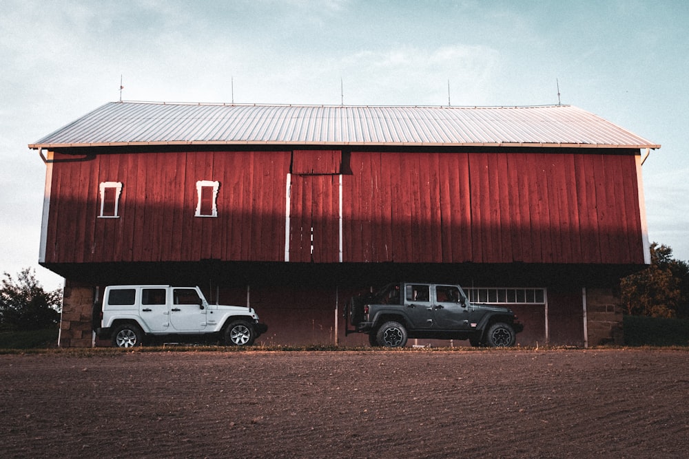 white and black cars parked beside red building