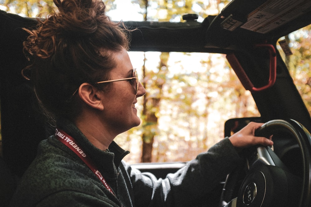 woman in black jacket driving car during daytime