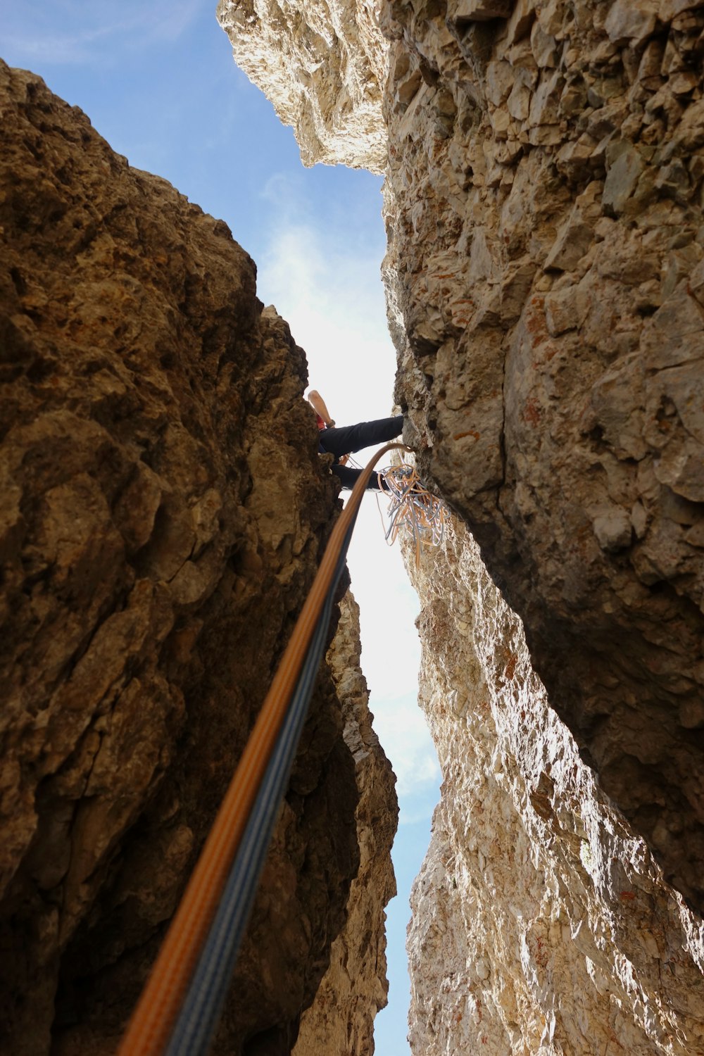 person climbing on brown rock mountain during daytime