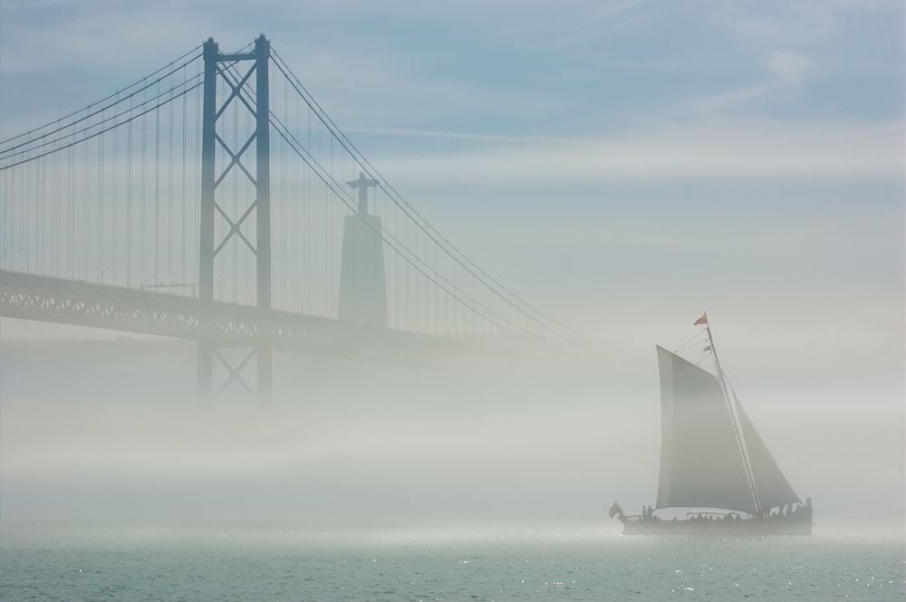 white sailboat on sea under white sky during daytime