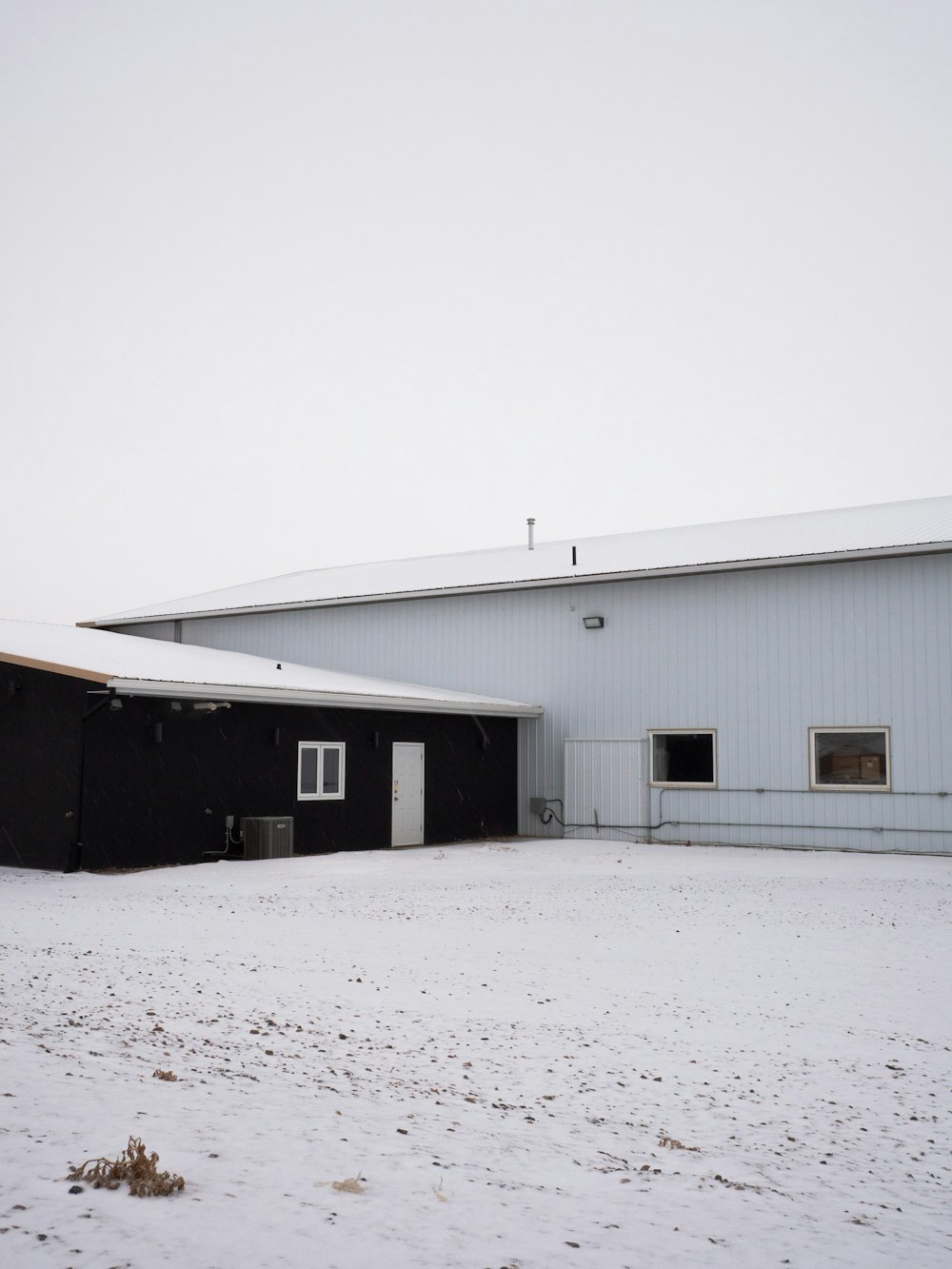 white and gray wooden house on snow covered ground