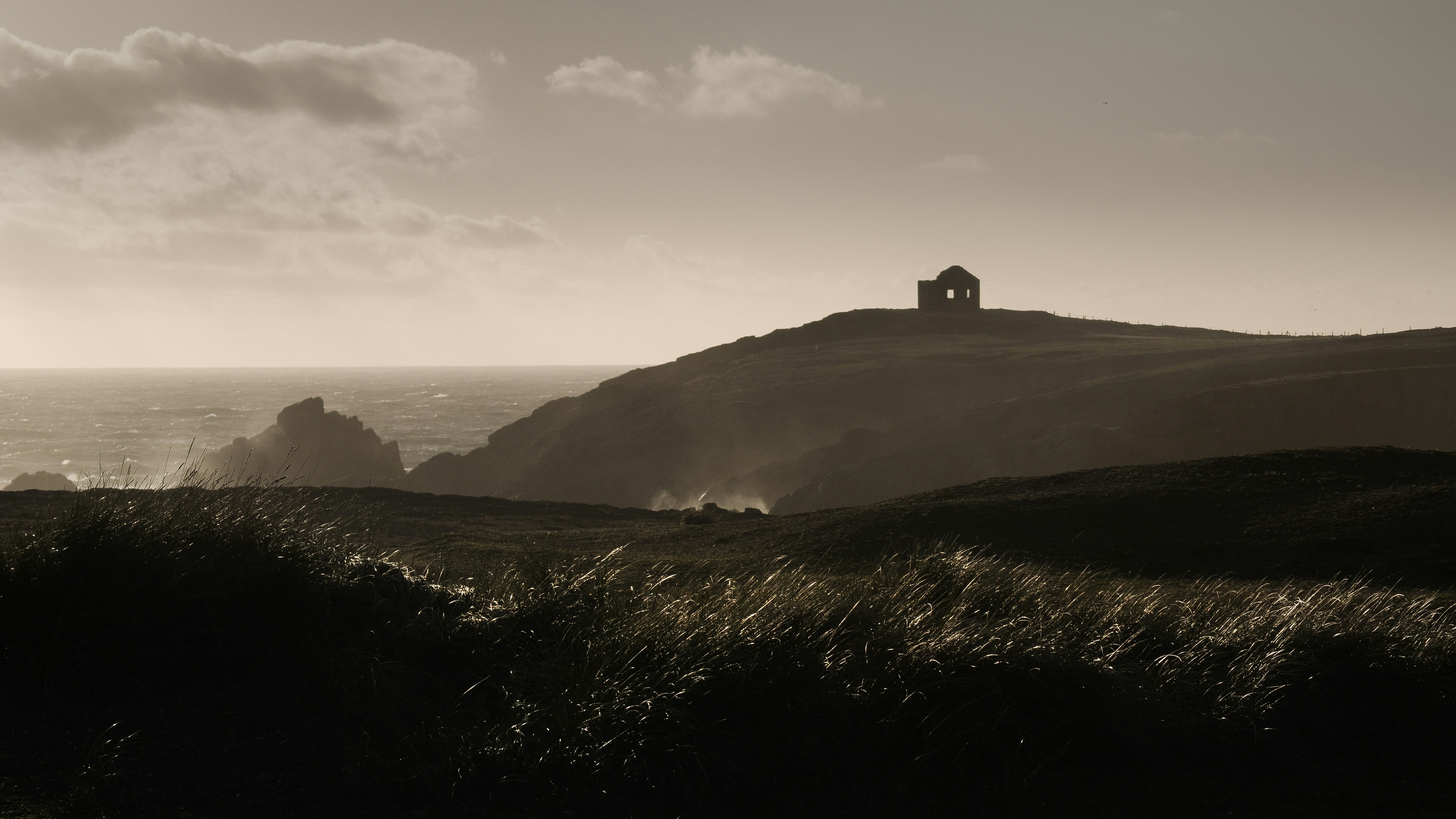 silhouette of person standing on top of hill during daytime
