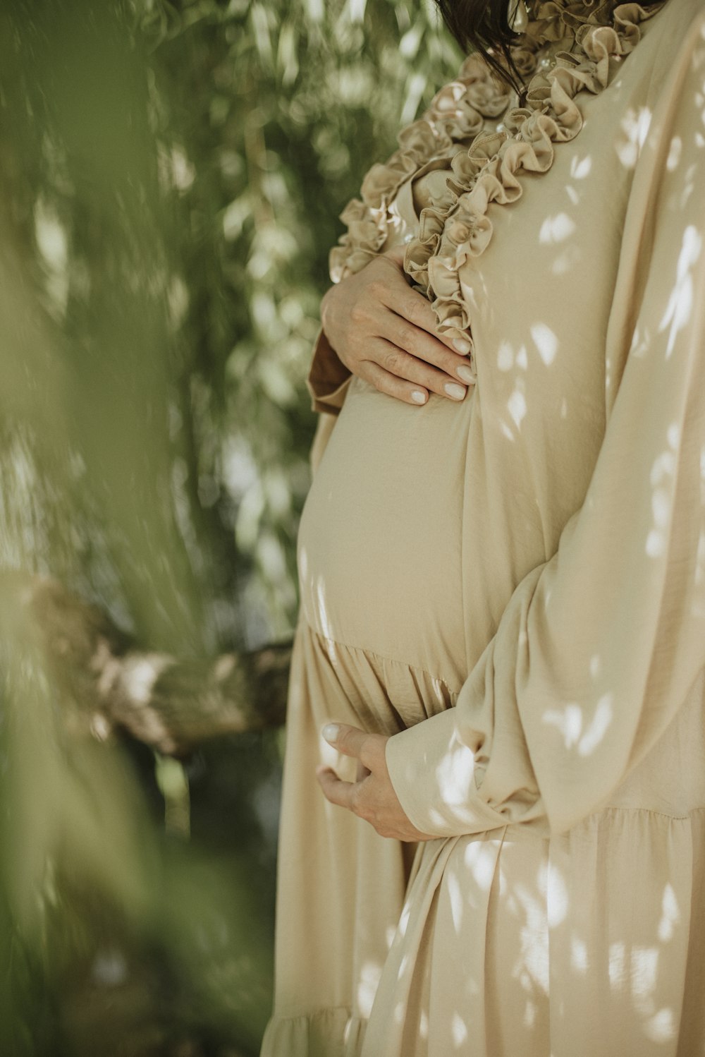 woman in beige and white floral dress wearing gold ring