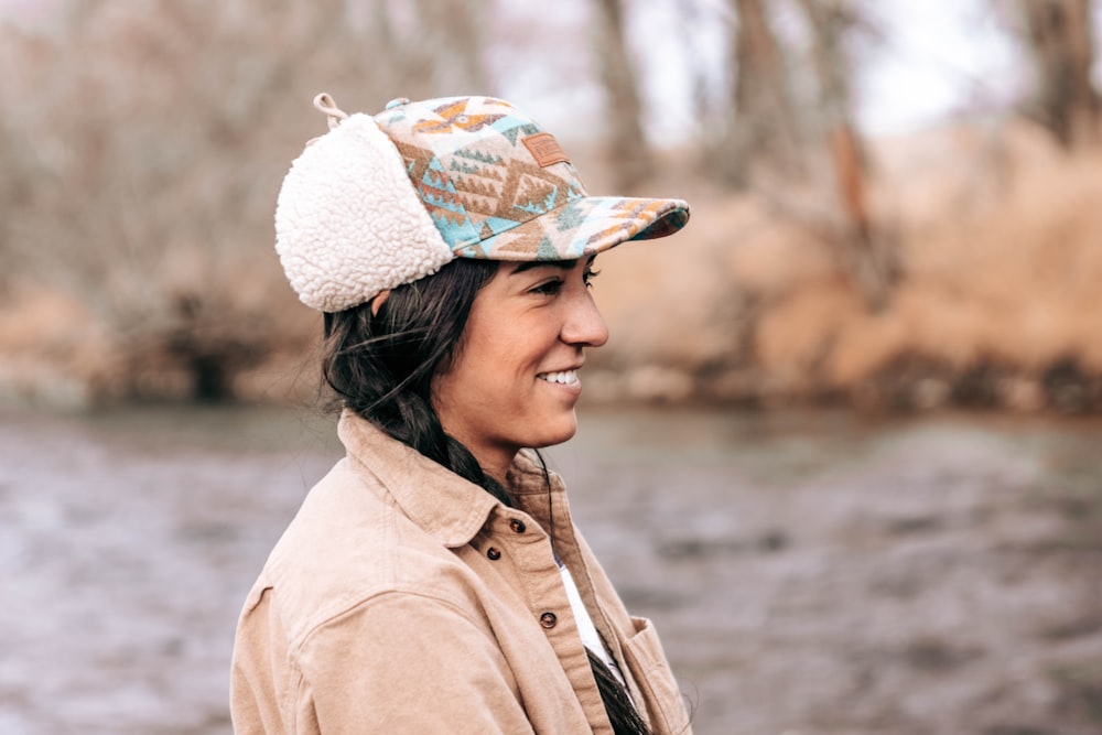 woman in brown coat wearing white knit cap