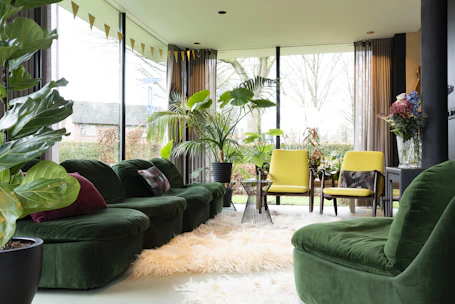 Bright minimalist living room with natural light and olive green accents.