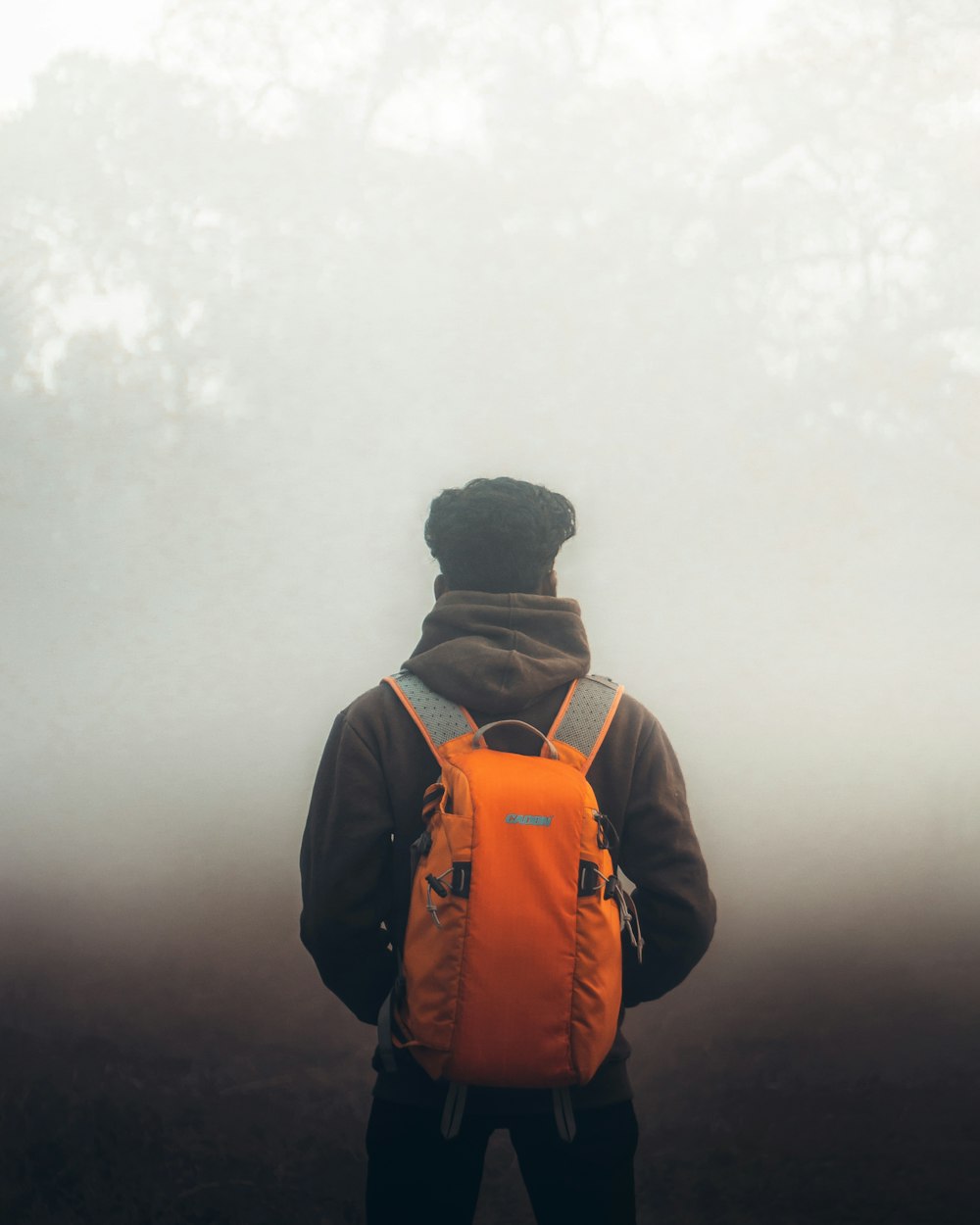 man in orange and black backpack