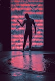 Silhouetted figure performing bodywork, framed by swirling shadows and subtle neon accents.