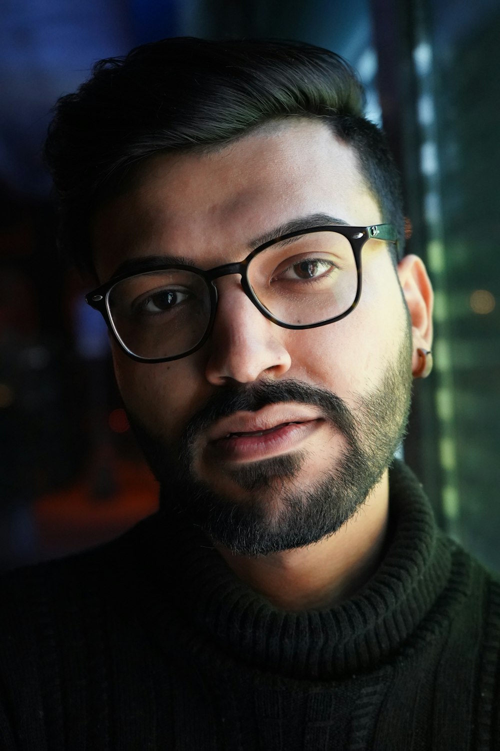 man in black framed eyeglasses and green turtleneck sweater