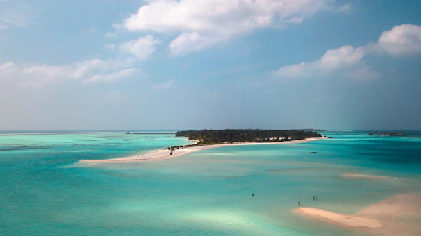 A serene private island in the Maldives with turquoise waters and white sandy beaches at sunset.