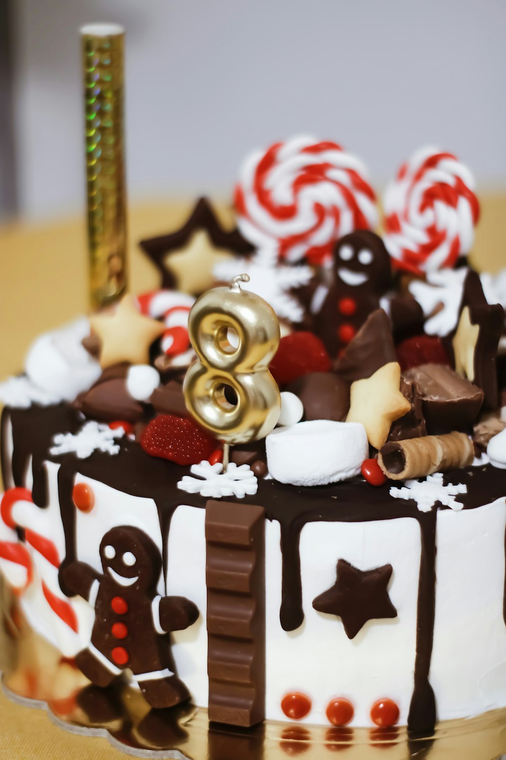 gâteau au chocolat avec glaçage blanc et pépites de bonbons rouges et dorés