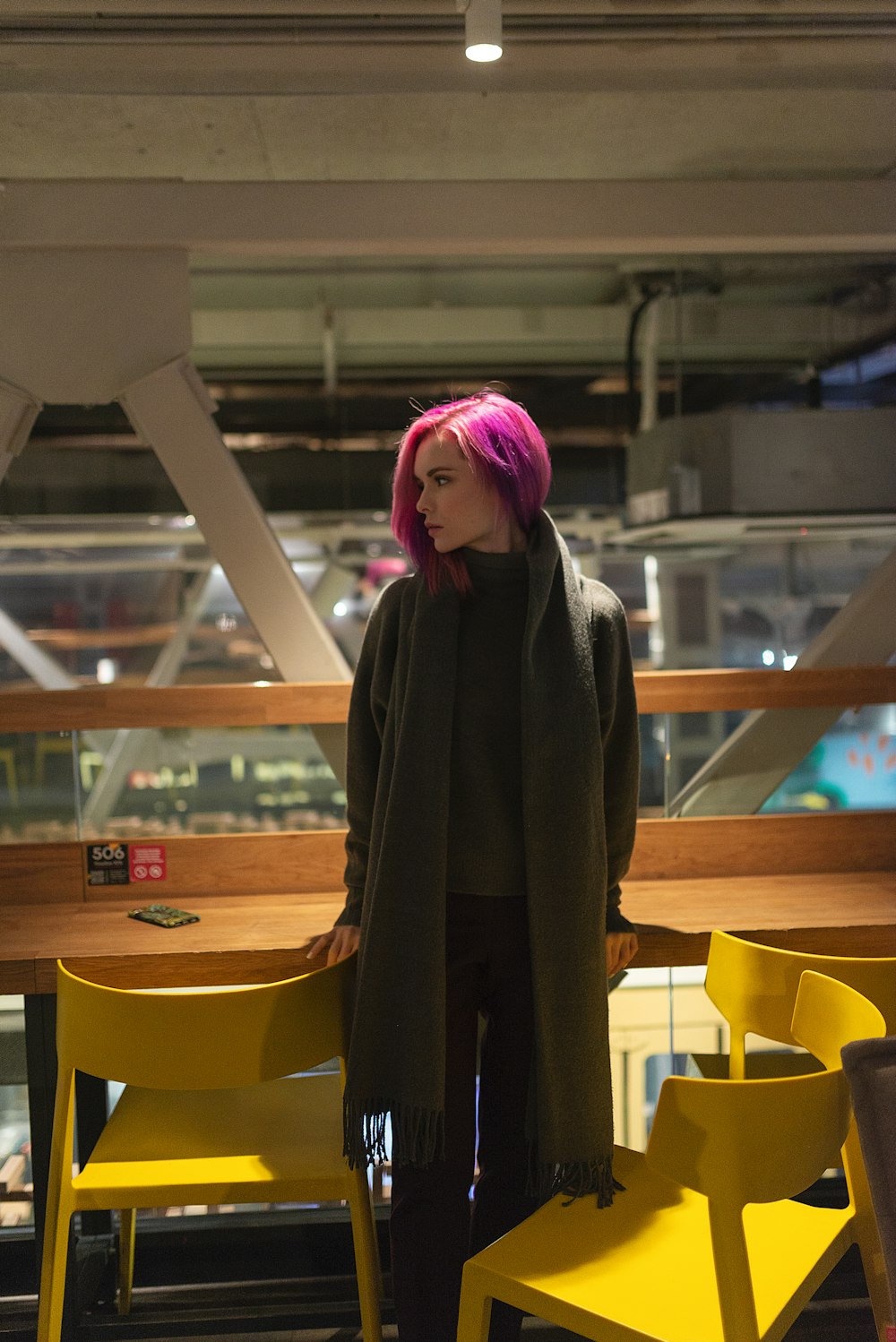 woman in black coat standing near brown wooden table