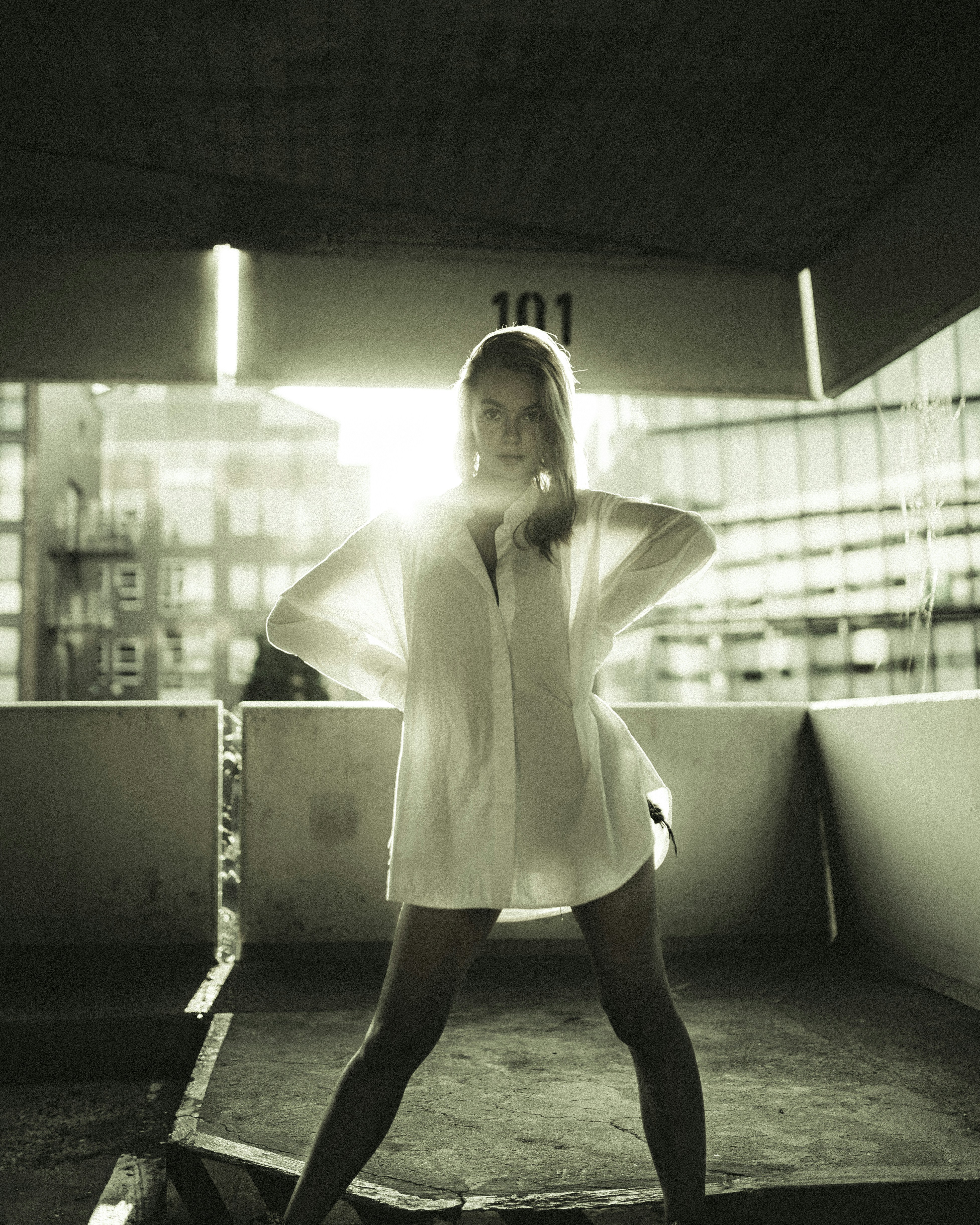 woman in white long sleeve shirt and black skirt standing on gray concrete floor