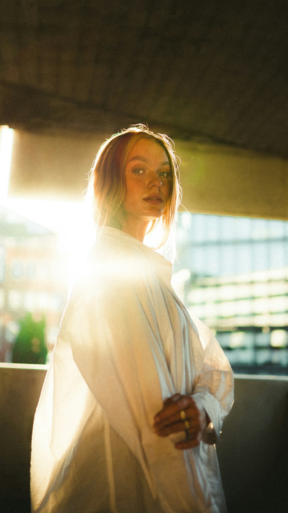 woman in white shirt standing near window