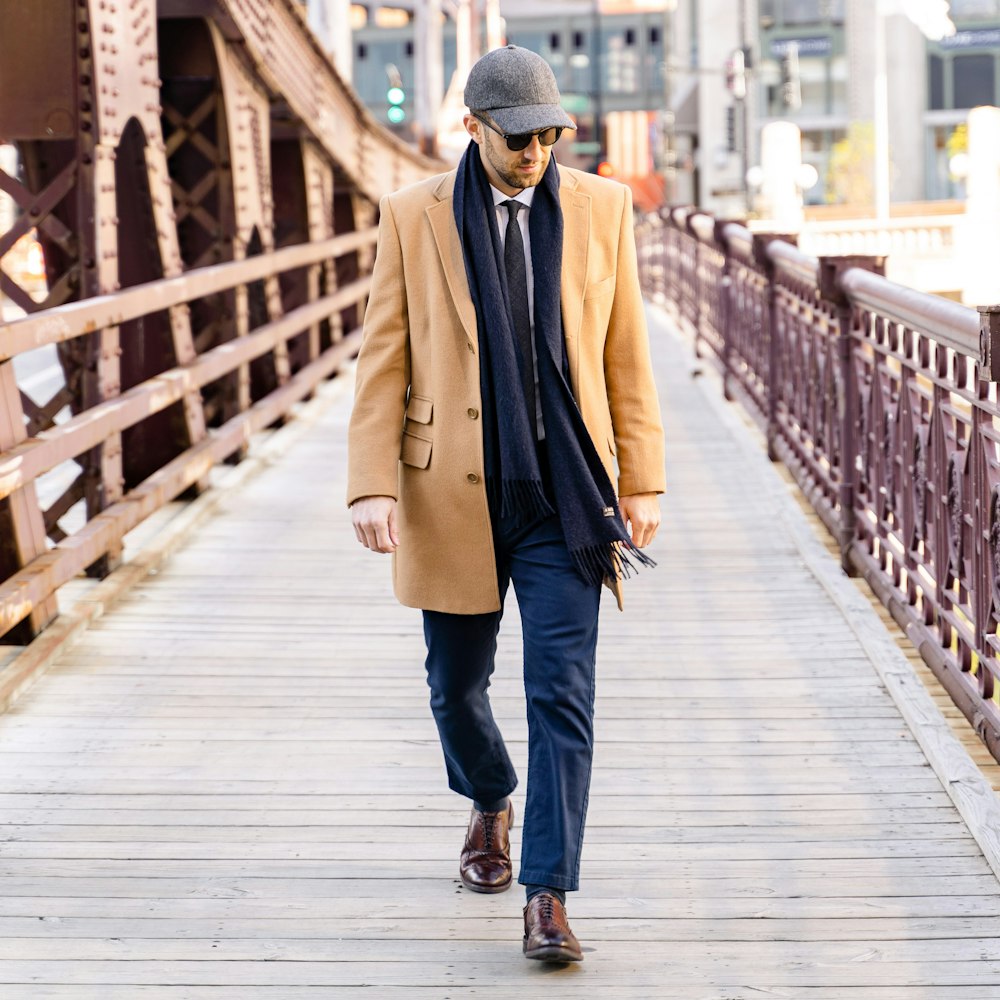 Foto Hombre con abrigo marrón caminando sobre un puente de madera durante  el día – Imagen Chicago gratis en Unsplash
