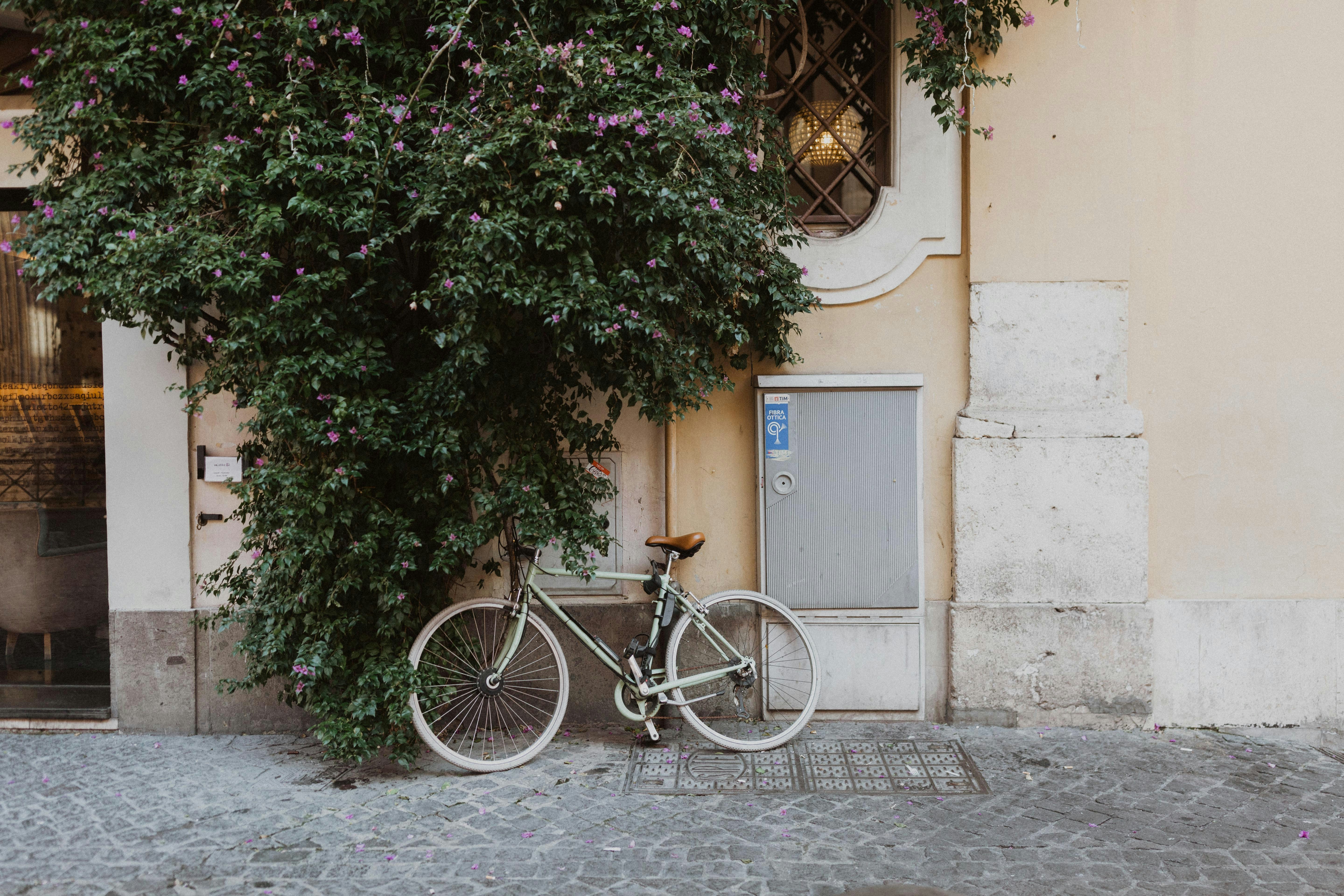 black city bike parked beside brown concrete building