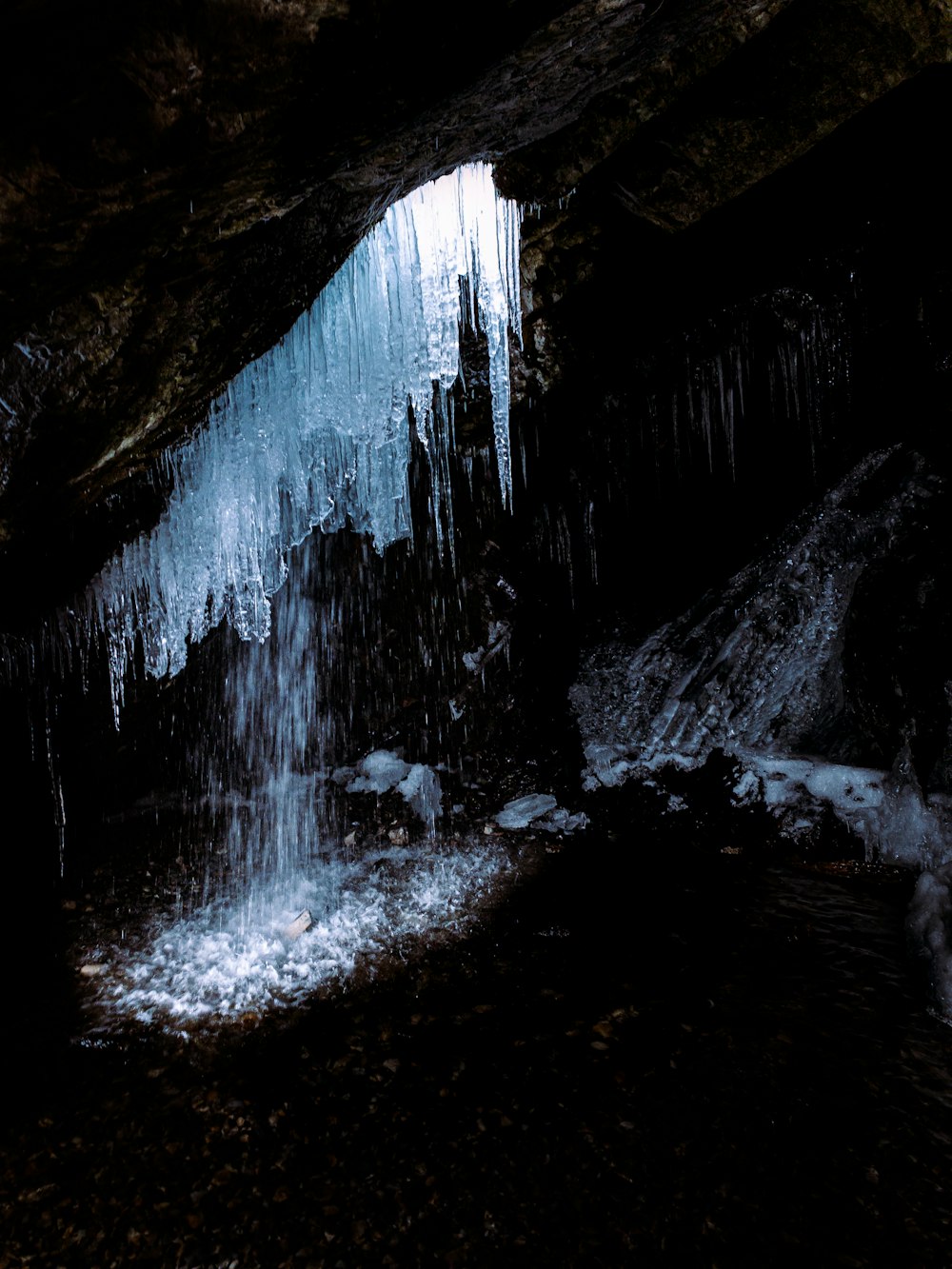 water falls in cave during daytime
