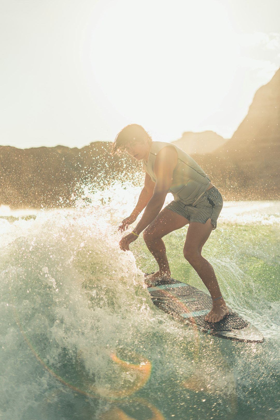 man in gray tank top and white shorts surfing on sea waves during daytime