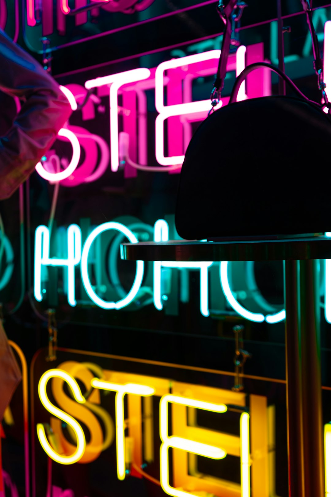 man in pink dress shirt standing near the neon light signage