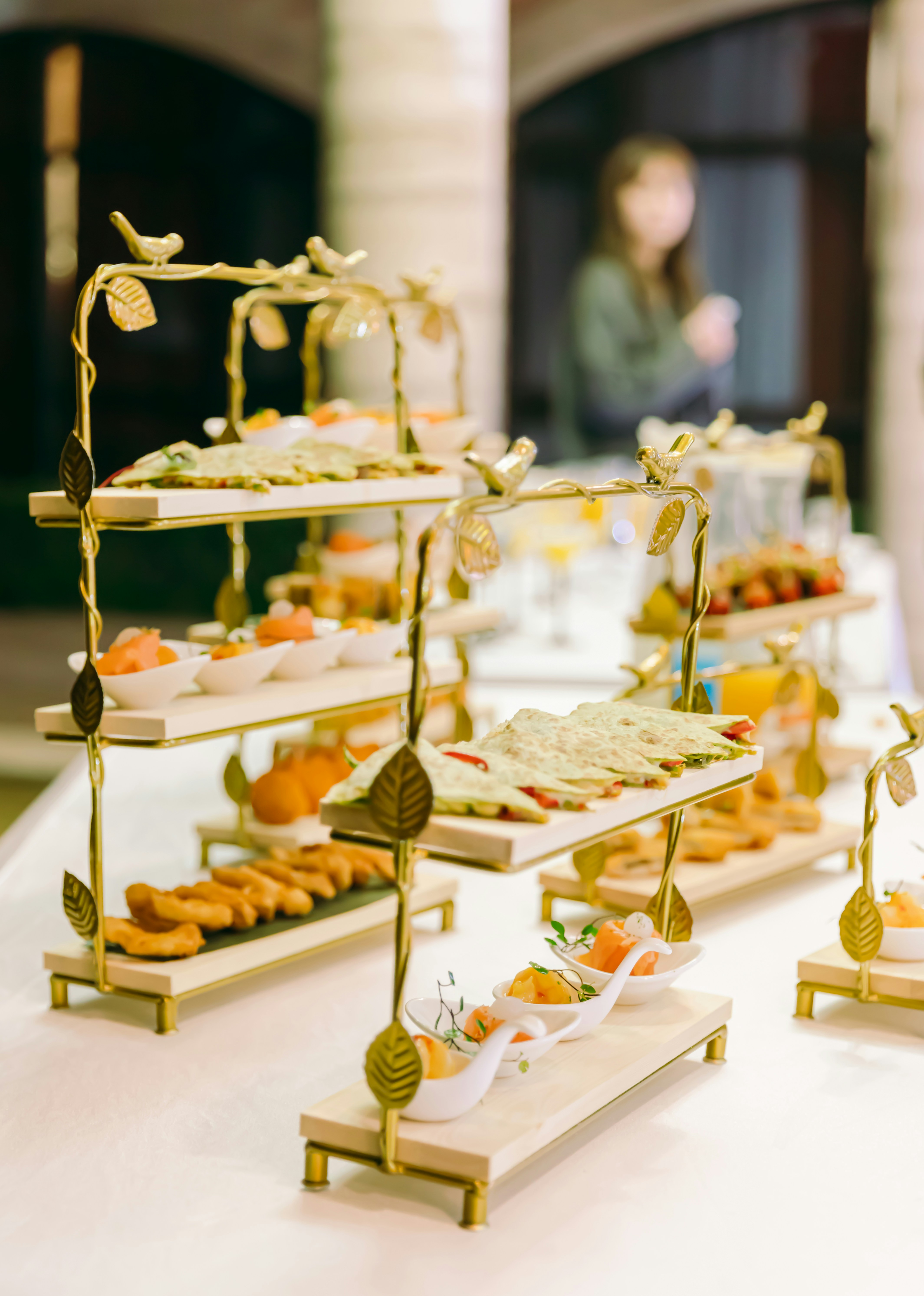 Elegante tavolo da buffet con antipasti su alzate dorate a più piani.
