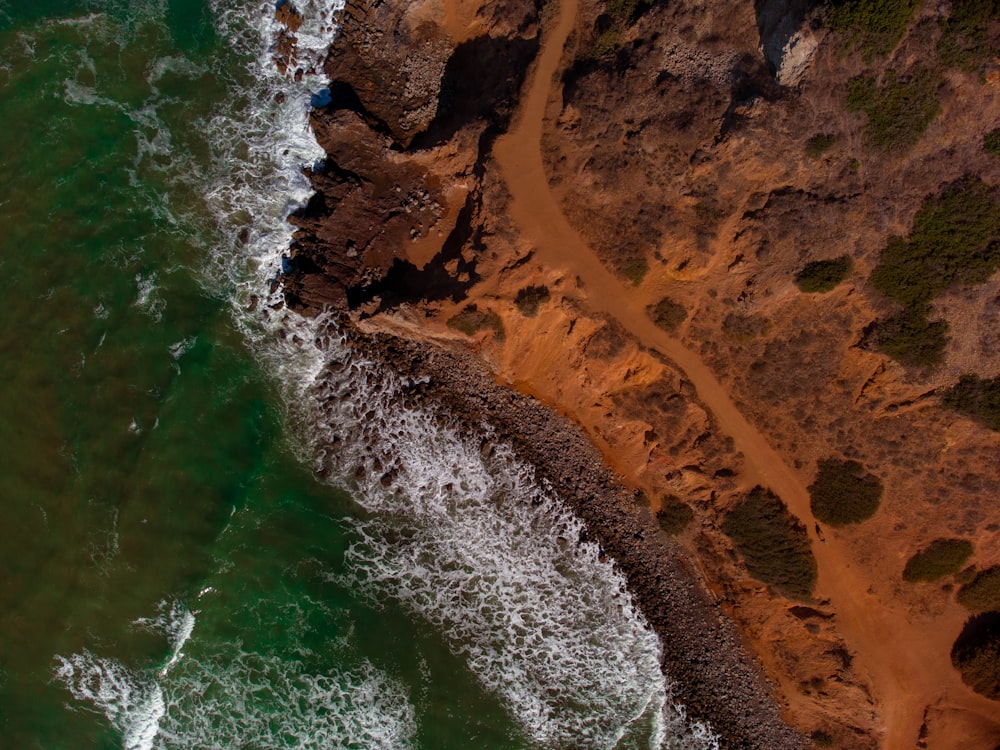 brown rock formation beside body of water during daytime