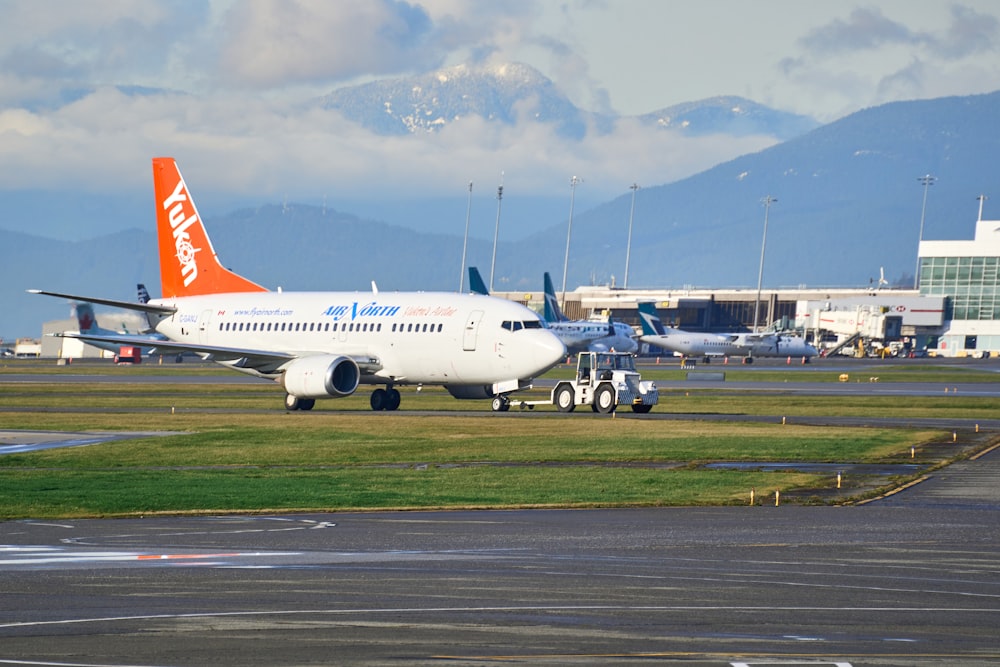 white and red passenger plane on airport during daytime