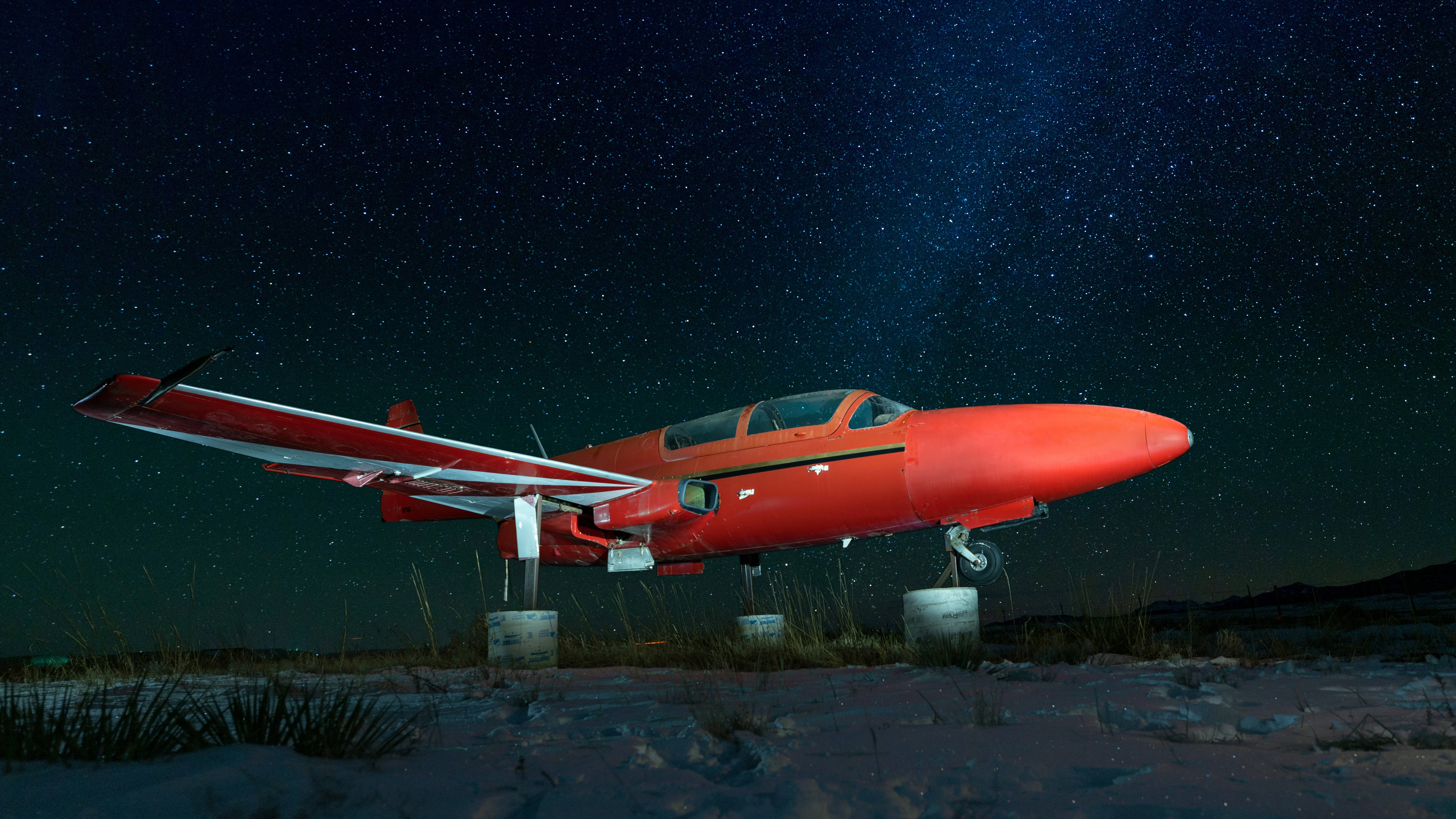 red and white plane on brown field during nighttime, Light painted vintage airplane.