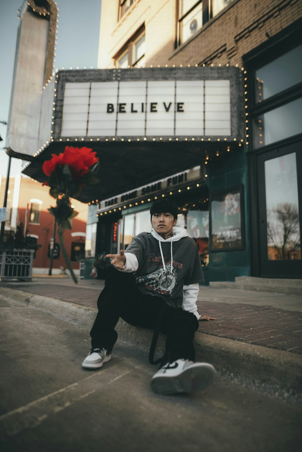 man in black and white jacket sitting on gray concrete bench