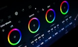 A digital interface displaying color correction tools with multiple color wheels for adjusting lift, gamma, and gain. The background is dark, emphasizing the brightness and saturation of the color wheels, which are arranged in a row. Each wheel is accompanied by numerical values and sliders for precise adjustments.